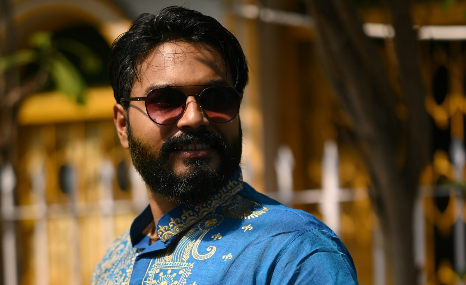 Bearded Indian model in a blue embroidered kurta and sunglasses